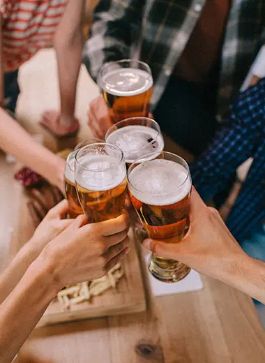 Un groupe de personne trinquant avec leurs verres de bière